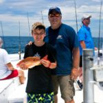 Young angler shows off his catch on a Destin party boat